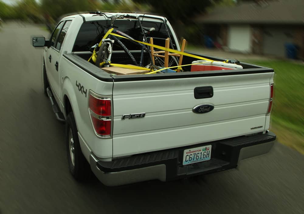  Wrap straps through and around items such as hand trucks and ladders. Secure the straps to anchor points in the bed of the truck or trailer. 