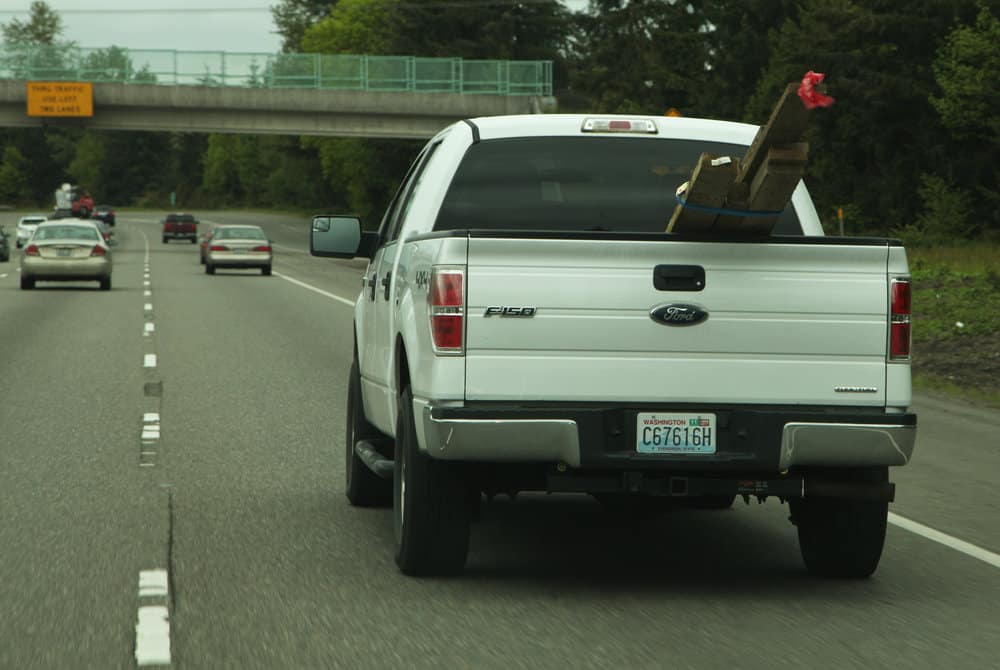  All corners of a load should be tagged with red flags (one foot by one foot), if the load extends four feet beyond the bed of a truck or trailer 