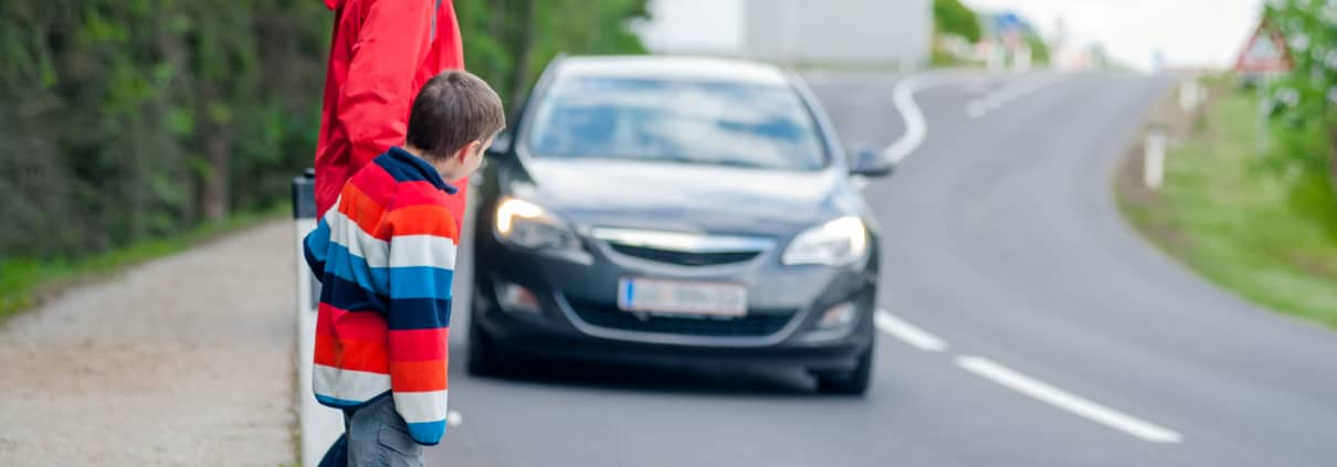 Mother and son passing a street when a car coming